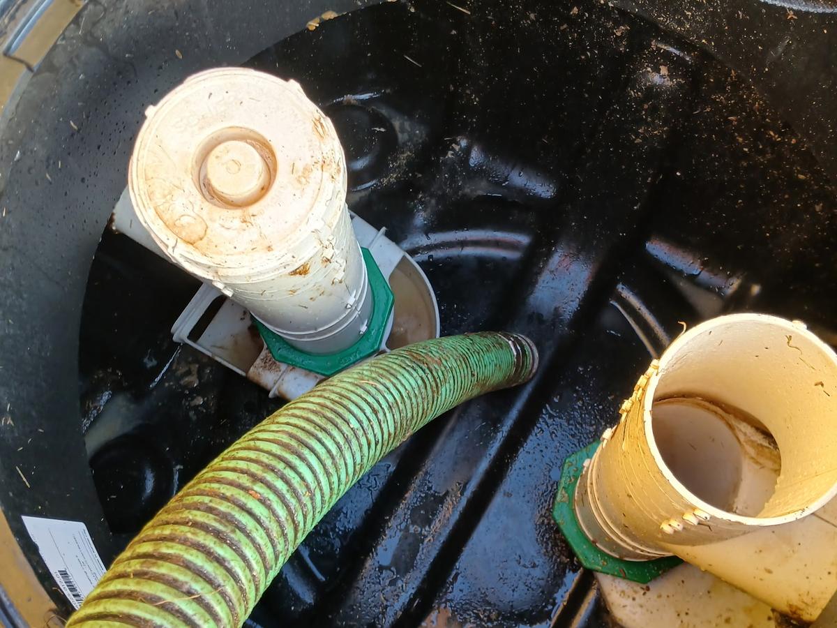 The same septic tank after pumping — tank drawn down with the inlet tee and outlet filter clear