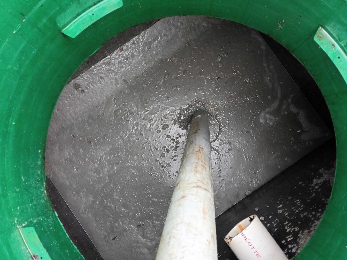 The same grease interceptor after pumping — chamber drawn down and the baffle wall clear